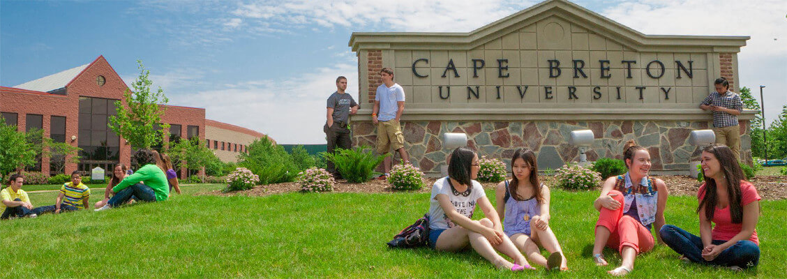 Several groups of students gathered around the Cape Breton University sign